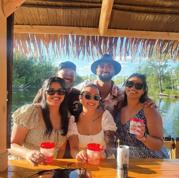 Friends with drinks under the palapa roof