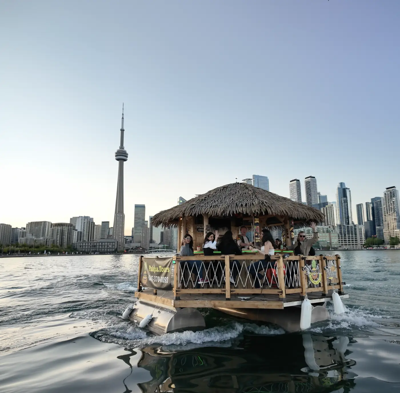 A Palapa floating tiki bar in front of the Toronto skyline
